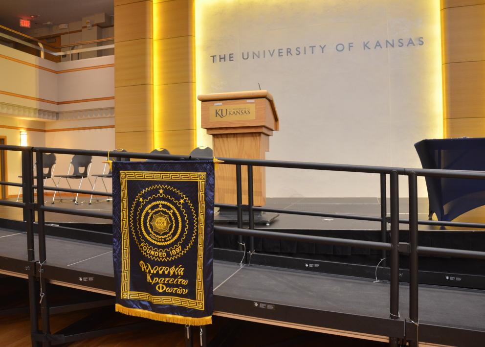 The stage is adorned with the Phi Kappa Phi Banner